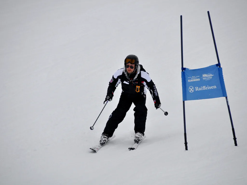 Skifahrer im schwarzen Anzug zwischen den Toren.